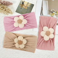 Three baby girl flower headbands in pink and beige with soft textured fabric
